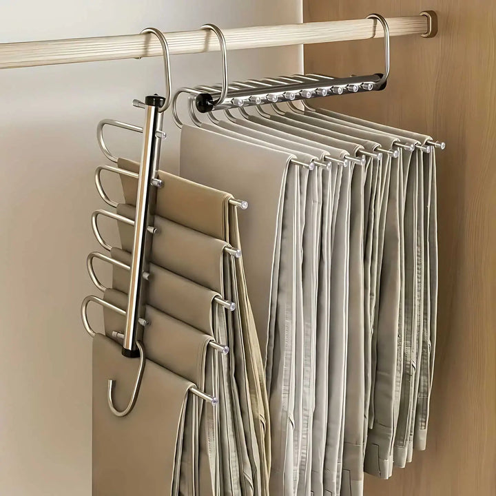 Zwei Edelstahl-Hosenbügel an einer Kleiderstange, einer seitlich ausgeklappt, der andere zusammengeschoben, beide dicht mit Stoffhosen behängt. 1