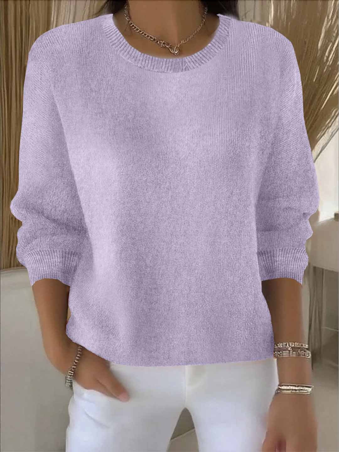 Frontansicht des fliederfarbenen Strickpullovers mit gerippten Bündchen, vom Model zu weißer Hose getragen 14