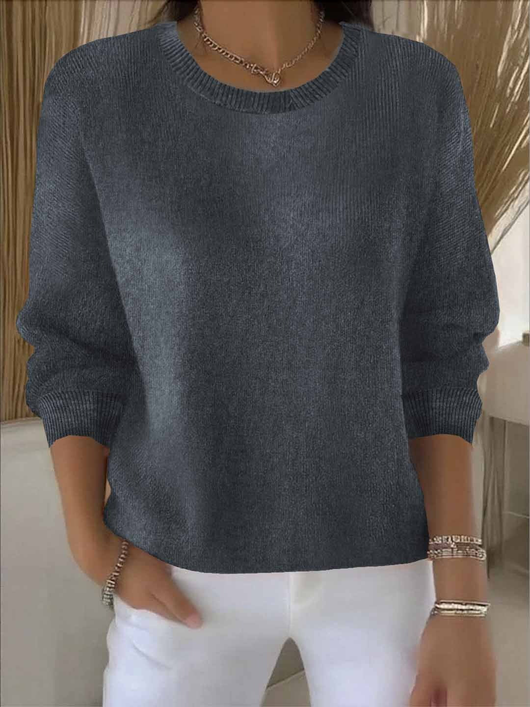 Frontansicht des grauen Strickpullovers mit gerippten Bündchen, vom Model zu weißer Hose getragen 6