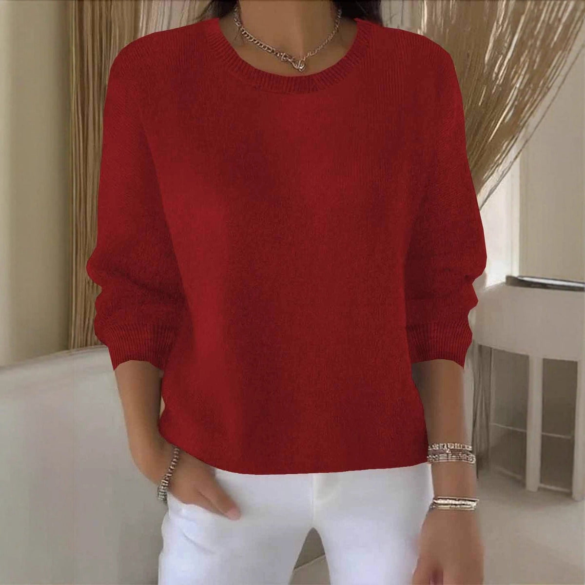 Frontansicht des roten Strickpullovers mit Rundhalsausschnitt, getragen zu weißer Hose und Silberschmuck 1