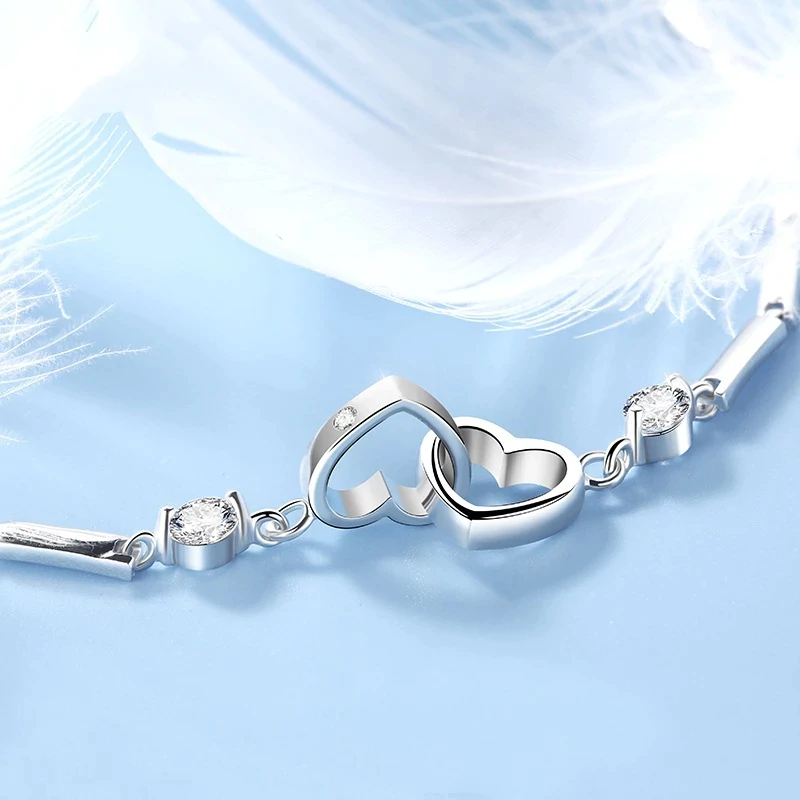 Silberarmband mit Herzanhänger und Kristallen, eleganter Schmuck für Damen, romantisches Design.