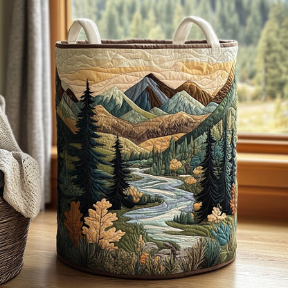 Runder gesteppter Stoffkorb mit Bergtal-Motiv aus Tannen, Fluss und Herbstlaub steht vor einem Fenster auf Holzboden, daneben ein Weidenkorb. 1