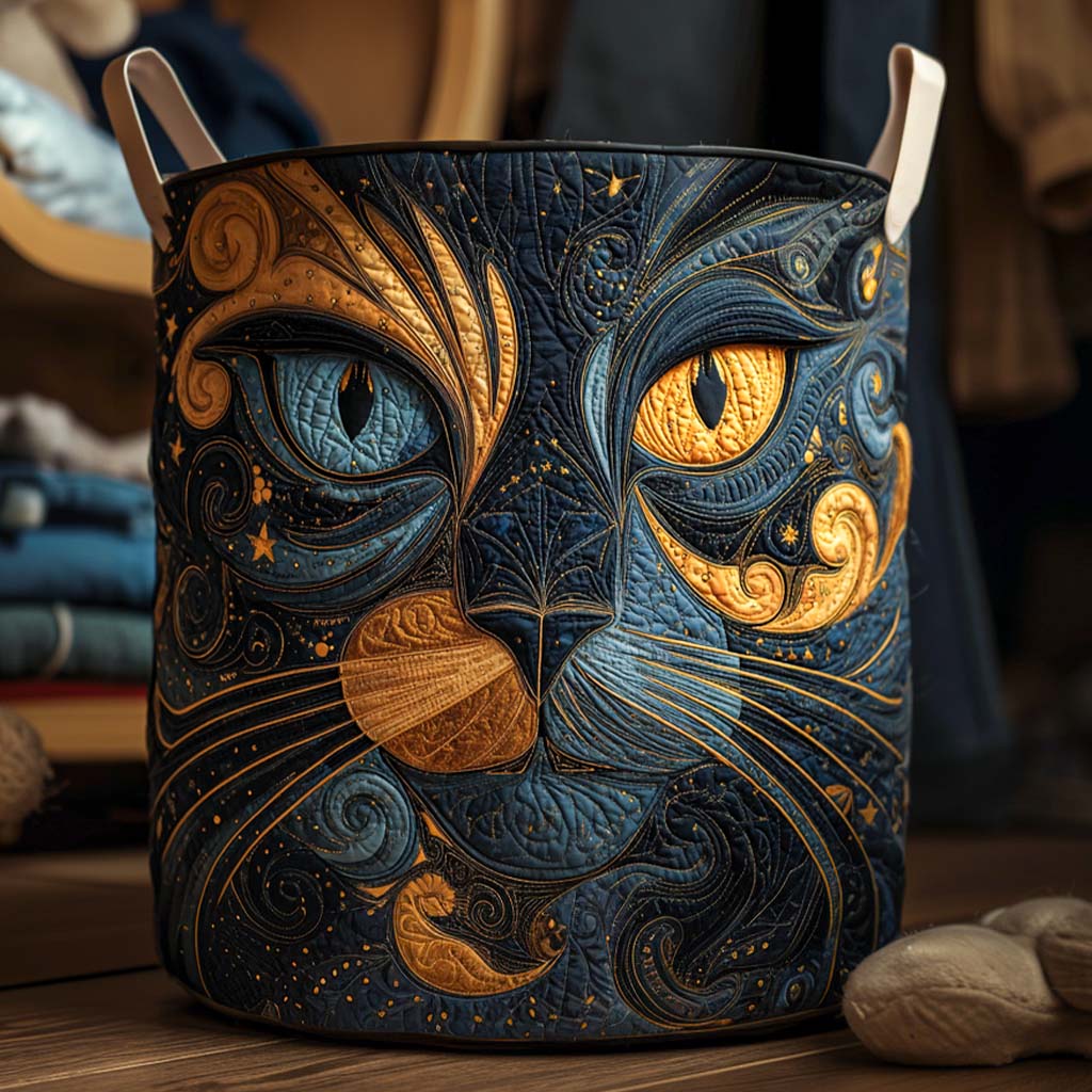 Runder, gesteppter Wäschekorb mit Katzengesicht in Blau und Gold und hellen Henkeln, auf einem Holzboden vor gestapelter Kleidung. 1