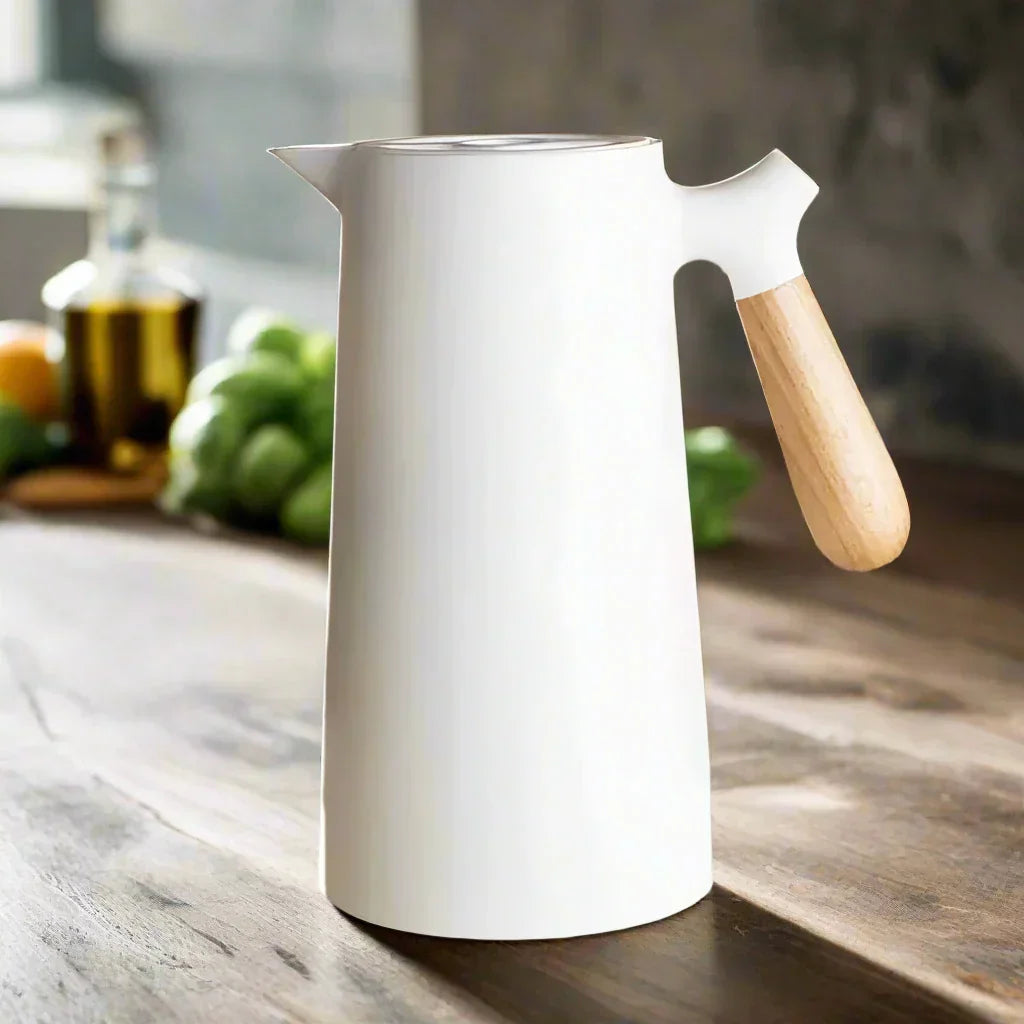 Weiße nordische Thermoskanne mit Holzgriff auf Holztisch, stilvolles Küchendesign.