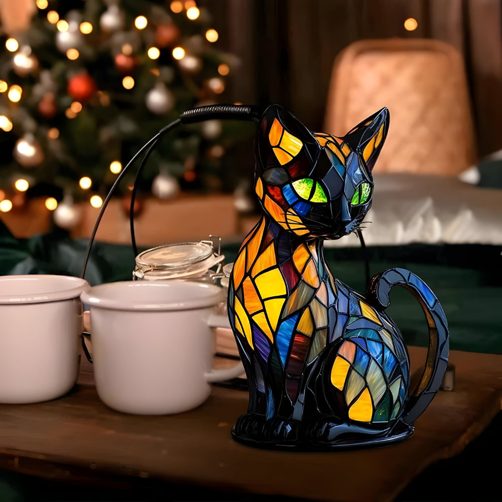 Katzenfigur mit Mosaikmuster auf einem Tisch neben weißen Bechern, im Hintergrund ein geschmückter Weihnachtsbaum 4