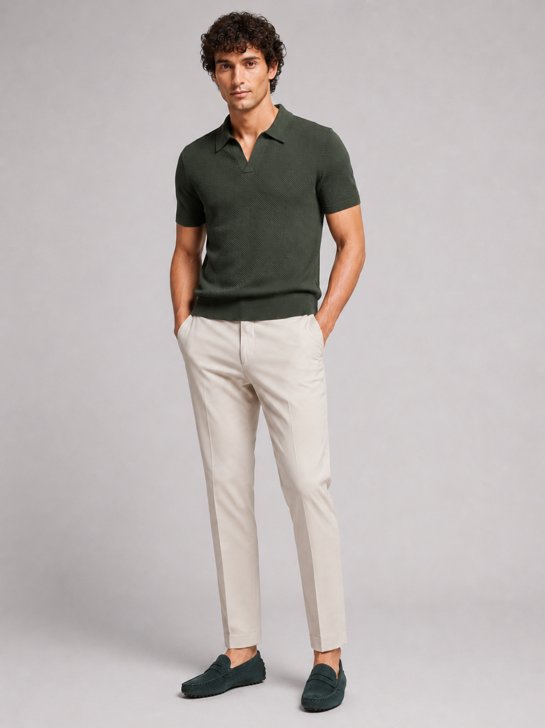 Ganzkörperansicht von vorne: dunkelgrünes Poloshirt, helle Hose und dunkelgrüne Wildleder-Loafer vor grauem Hintergrund 13