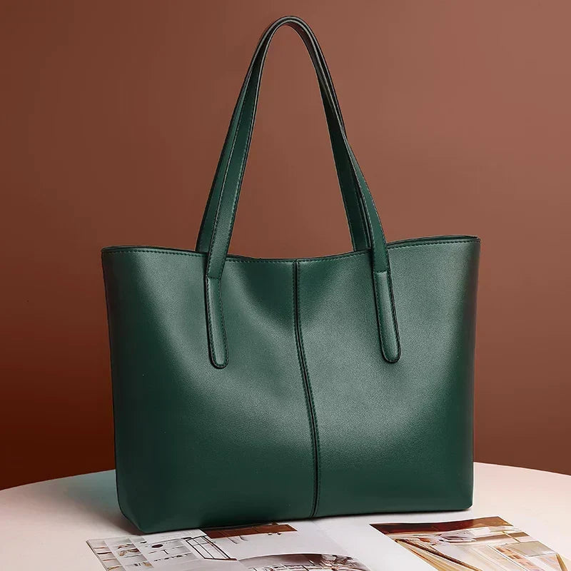 Grüne Tote-Tasche schräg von vorn auf einem Tisch vor brauner Wand, mit Zeitschrift im Vordergrund 4