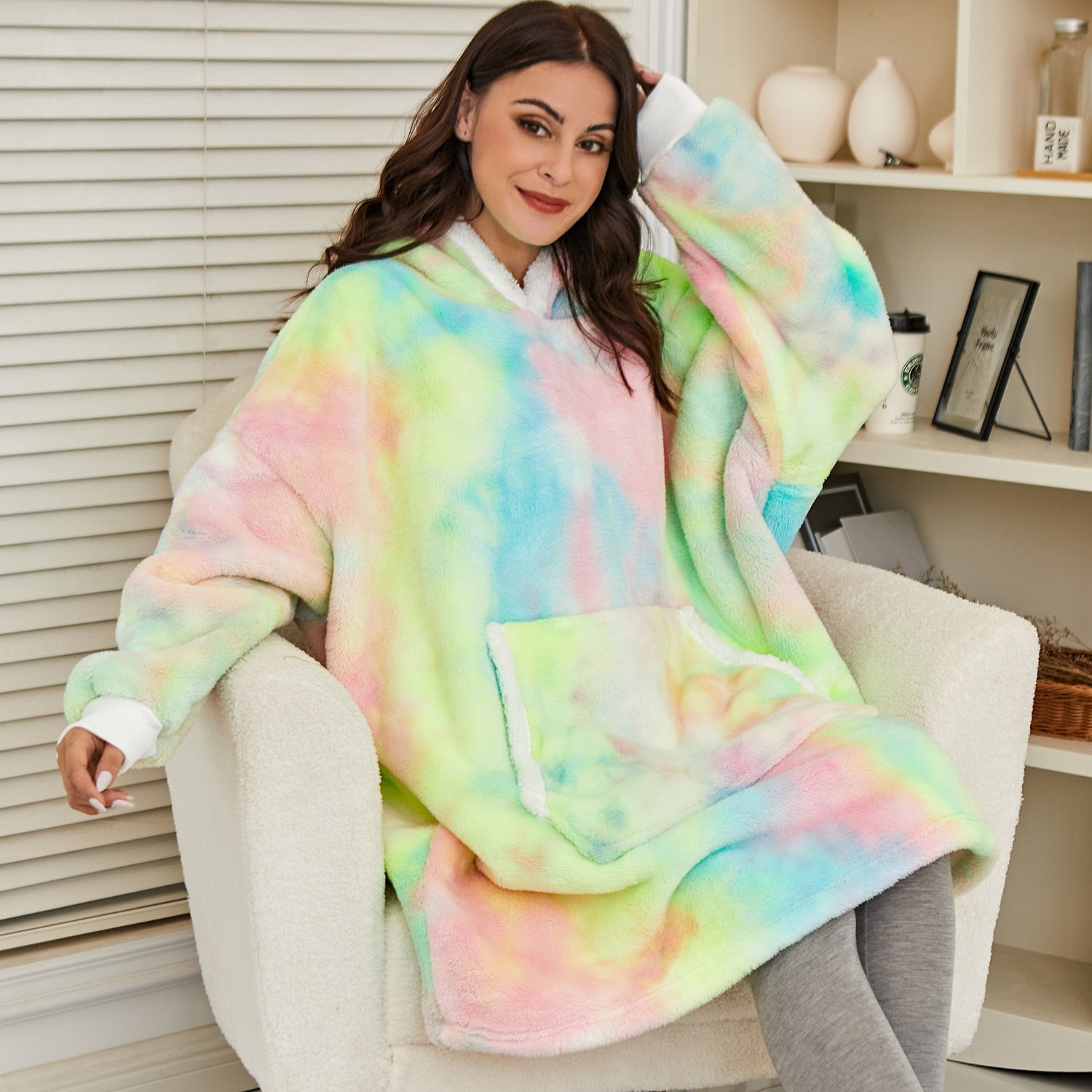Frau in buntem, übergroßem Hoodie-Decke, gemütlich, weich, pastellfarben, Wohnzimmer.
