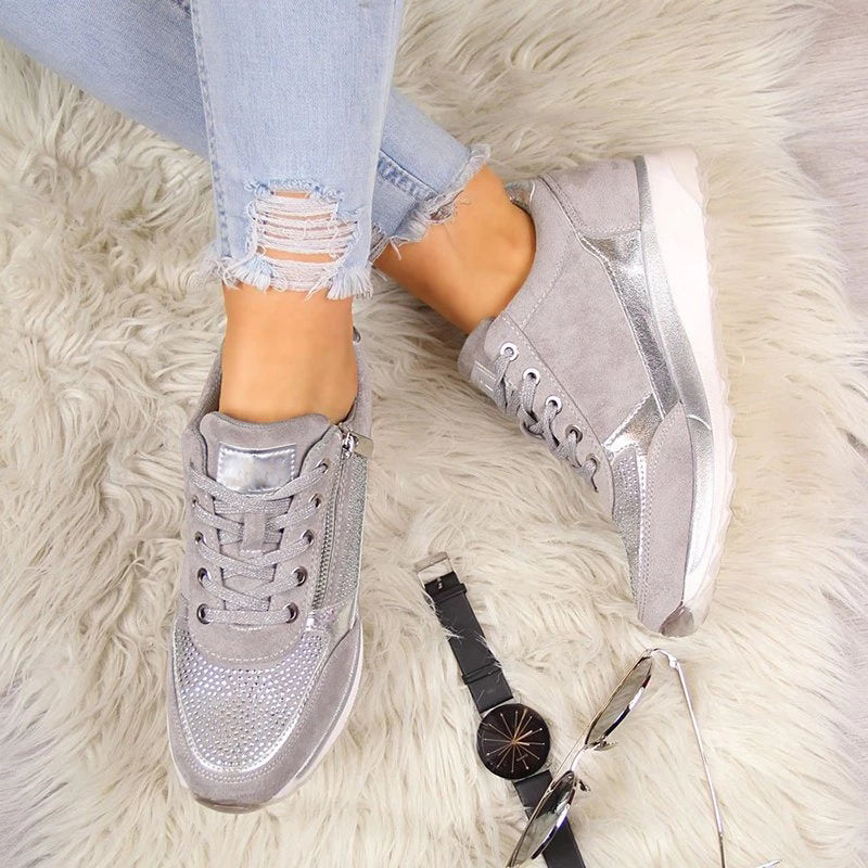 Graue Schuhe von oben auf flauschigem Teppich, daneben Armbanduhr und Sonnenbrille, dazu Jeans mit Rissen am Saum. 6