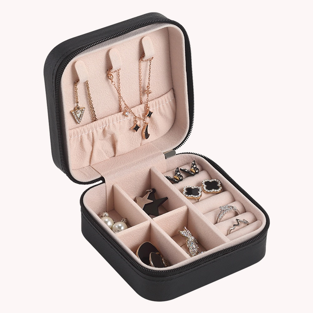 Schwarze Schmuckbox mit Fächern, Ohrringen und Ketten, ideal für Reisen und Aufbewahrung.