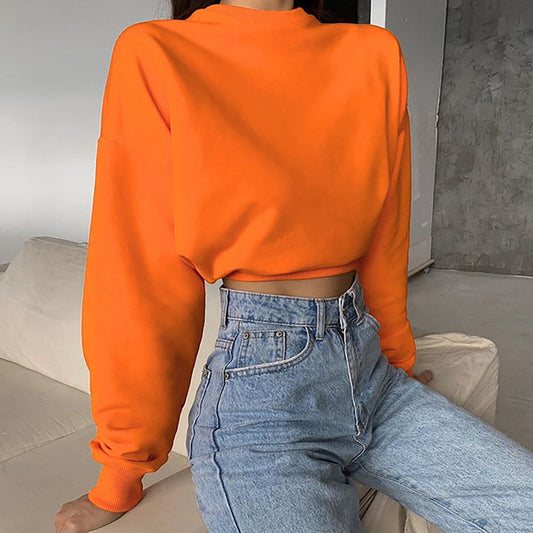 Frau in orangefarbenem Pullover und blauer Jeans, modisch, lässig, Herbstmode.