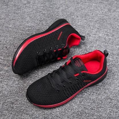 Schwarze und rote Sportschuhe, atmungsaktiv, rutschfest, für Herren, auf grauem Teppich.