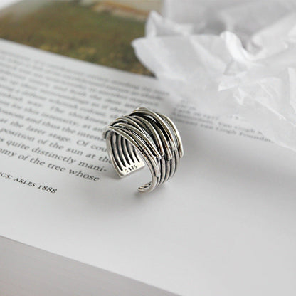 Silberner, verstellbarer Ring auf Buchseite, modernes Design, Schmuck für Damen und Herren.