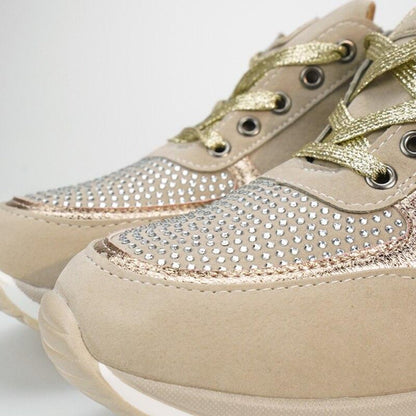 Nahaufnahme der Schuhspitzen mit dicht gesetzten Strasssteinen, goldfarbenen Schnürsenkeln und weicher Sohle am beigen Modell. 10