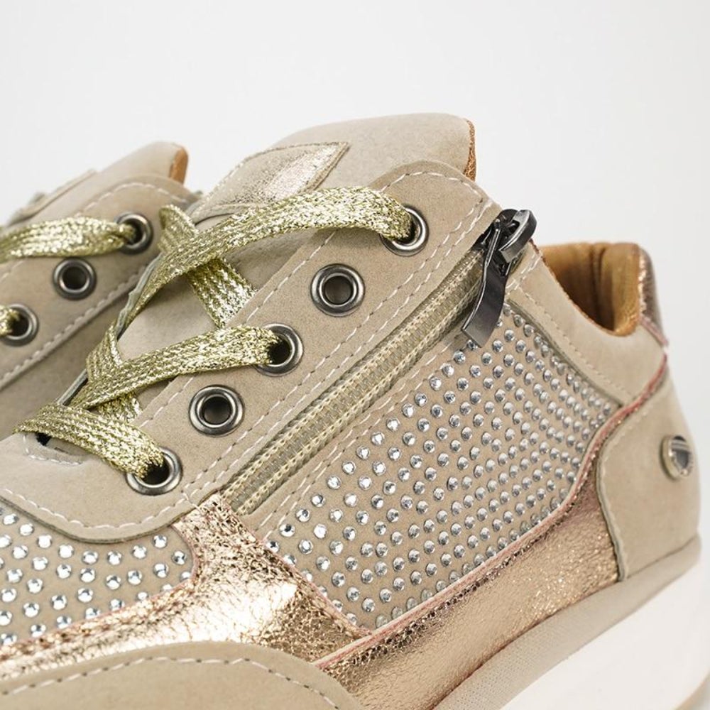 Nahaufnahme von Schnürung, Metallösen, Reißverschluss und Strasssteinen am beigen Schuh mit goldfarbenen Schnürsenkeln. 8