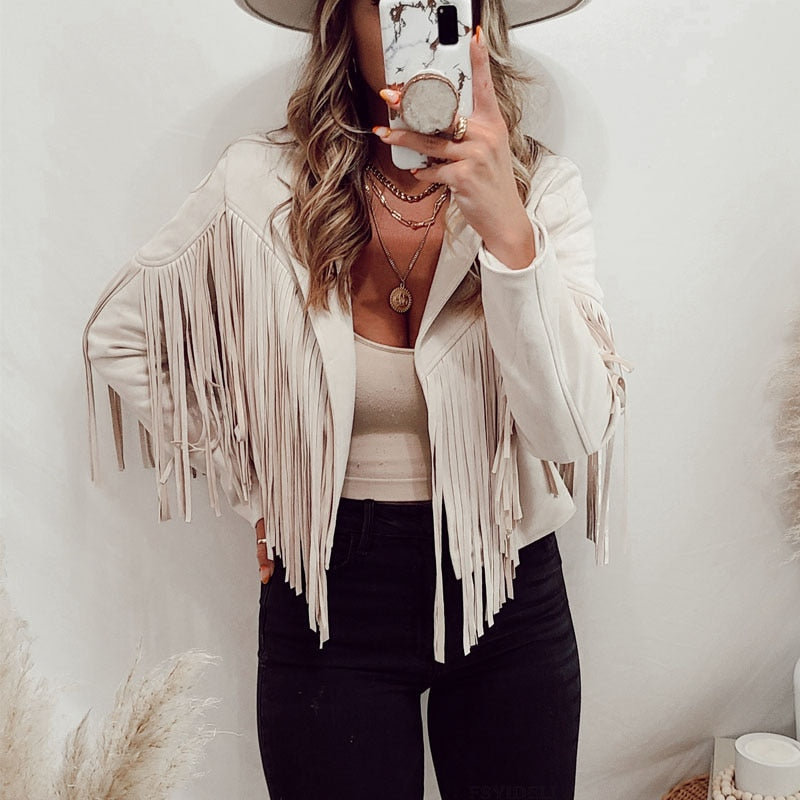 Frau in weißer Fransenjacke, schwarzer Hose, Hut, Spiegel-Selfie, modisch, Boho-Stil.