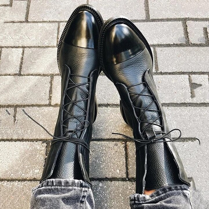 Schwarze Lederstiefel mit Schnürung auf Pflastersteinen, modisch, robust, Damenstiefel.