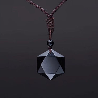 Schwarzer geometrischer Anhänger aus Onyx an braunem Lederband, eleganter Schmuck.