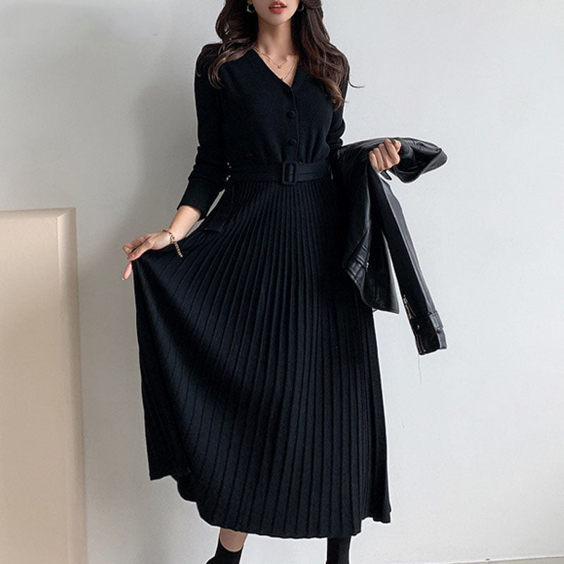 Frau in schwarzem, plissiertem Maxikleid mit Gürtel und Lederjacke, elegante Damenmode.