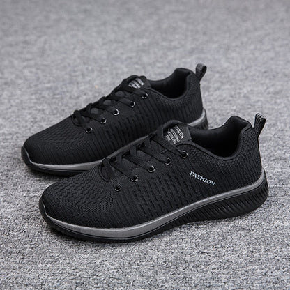 Schwarze Herren-Sneaker, atmungsaktiv, rutschfest, modisch, auf grauem Teppich.