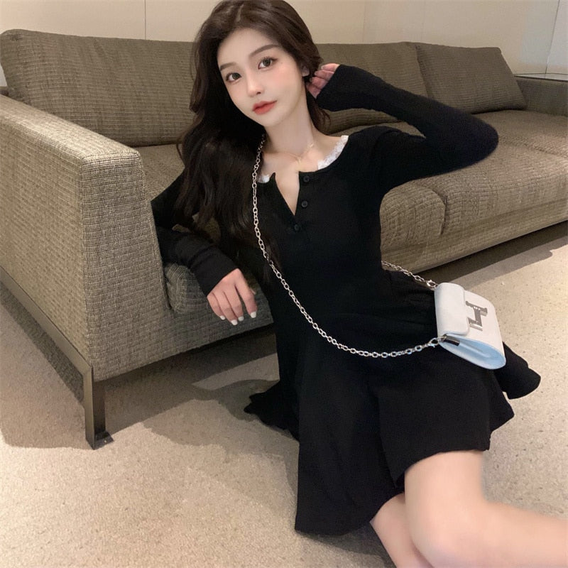 Frau in schwarzem Kleid mit weißer Umhängetasche auf Sofa sitzend, modisch, elegant.