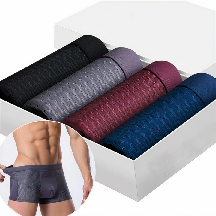 Vier aufgerollte Boxershorts in Schwarz, Grau, Weinrot und Blau im weißen Karton, daneben ein Model im Ausschnitt 1