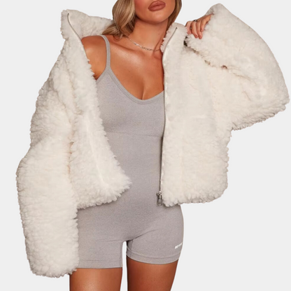 Frau in weißer Teddyjacke und grauem Jumpsuit, modische Winterbekleidung, Damenmode.