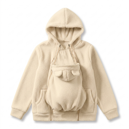 Cremefarbener Sherpa-Hoodie als Flat Lay mit eingesetztem Babytrageeinsatz, Bärenöhrchen, Doppelreißverschlüssen und Seitentaschen. 11