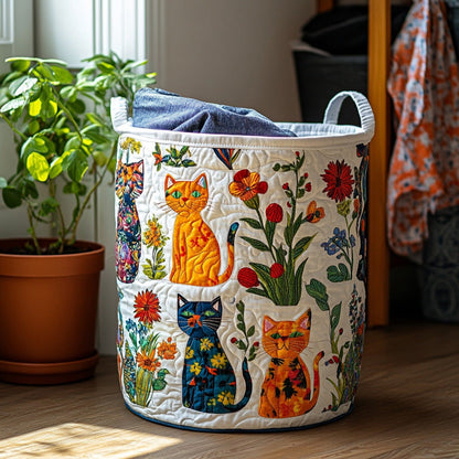 Runder gesteppter Wäschekorb mit bunten Katzen und Blumen und zwei Henkeln, mit Wäsche gefüllt, neben einer Topfpflanze am Fenster. 1