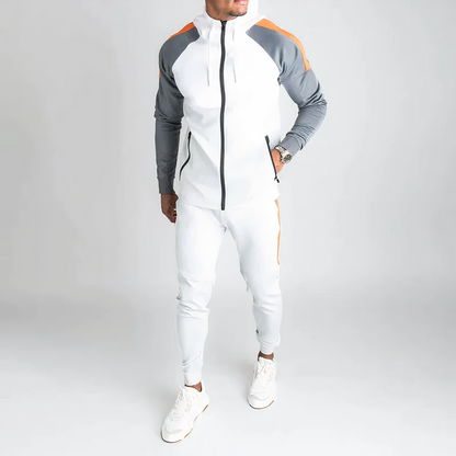 Mann in weißem Trainingsanzug mit grauen und orangefarbenen Akzenten, Sportmode, Fitnessbekleidung.