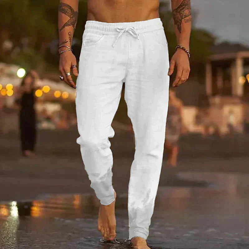 Mann in weißen Leinenjogginghosen am Strand, Sommermode, Freizeitkleidung, Herrenbekleidung.