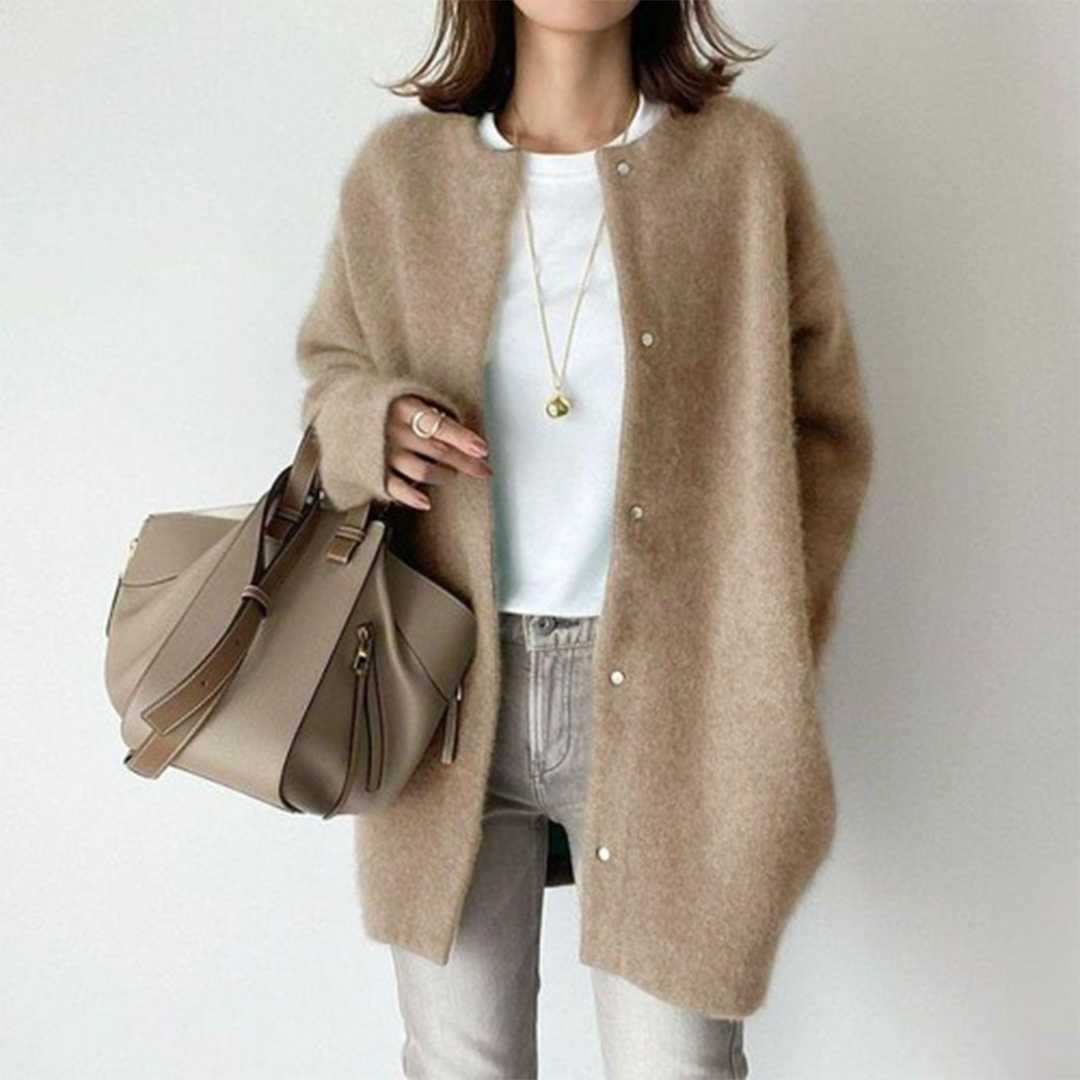 Frau trägt die flauschige Strickjacke in Beige mit Druckknöpfen zu weißem Shirt, heller Jeans und Handtasche 1