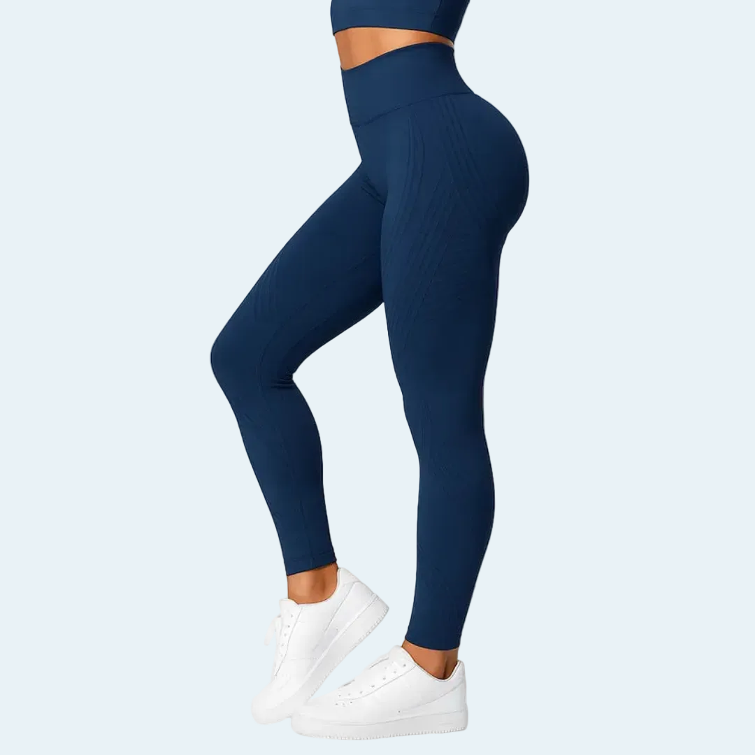 Seitenansicht der marineblauen Leggings mit hohem Bund an einem Model mit passendem Top und weißen Sneakern. 4