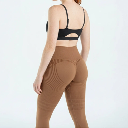 Rückansicht der braunen Leggings am Model, hoher Bund, geformte Gesäßpartie und Streifenmuster an Oberschenkeln. 8
