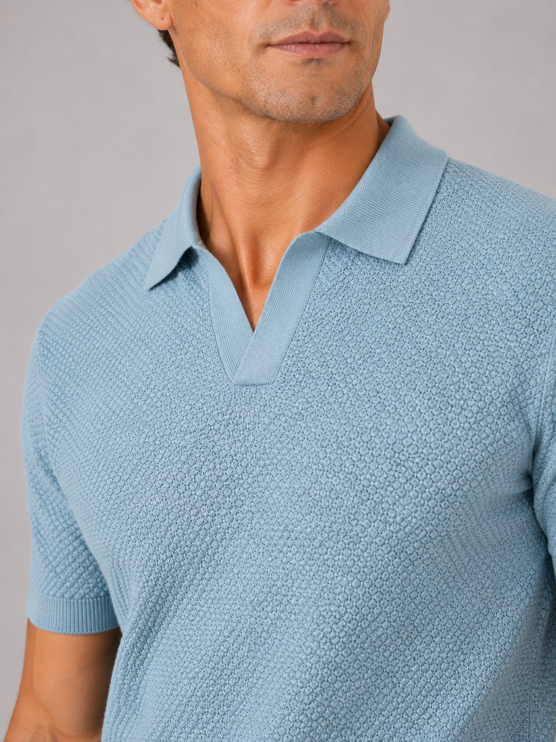Nahaufnahme von Kragen und Brustpartie des hellblauen Poloshirts mit offenem V-Ausschnitt und feiner Wabenstruktur 2
