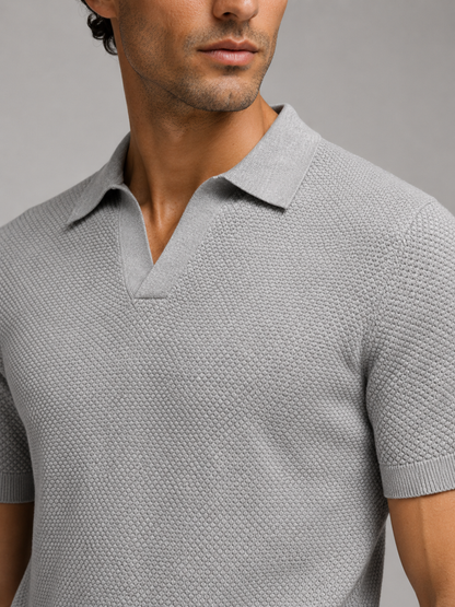 Detailaufnahme des grauen Strickpolos mit feiner Wabenstruktur, V-Ausschnitt, Kragen und Ärmelbündchen 27