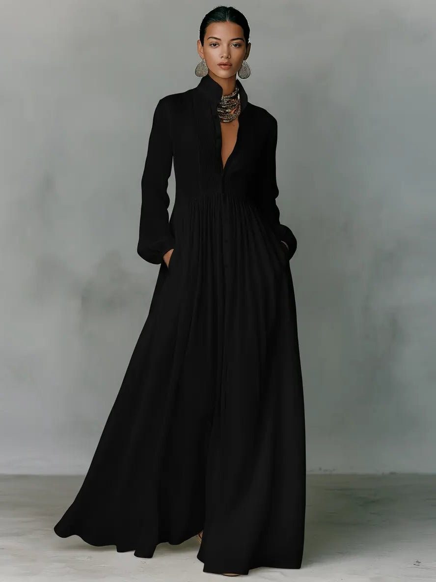 Das Maxikleid in Schwarz, getragen von einem Model, Frontansicht mit Stehkragen und fließendem Rock 4