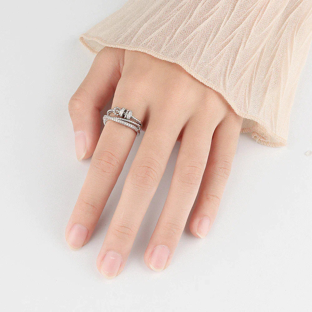 Damenhand mit silbernem Diamantring-Set, elegantes Schmuckdesign, Nahaufnahme.