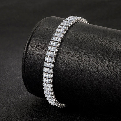Silbernes Tennisarmband mit rechteckigen Zirkonia-Steinen auf schwarzem Hintergrund.