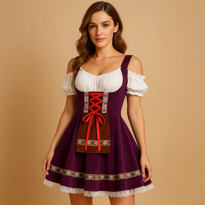 Model im violetten Dirndlkleid mit schulterfreier weißer Bluse, roter Schnürung, brauner Schürzentasche, Blumenborte und weißem Spitzensaum. 2