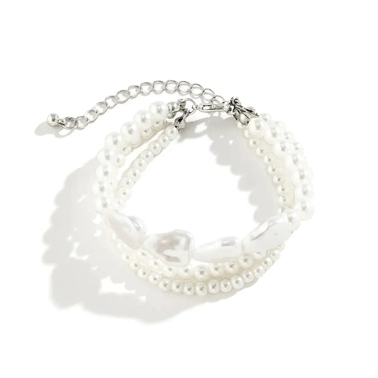 Dreireihiges Armband aus weißen Perlen mit verstellbarem Verschluss, eleganter Schmuck.