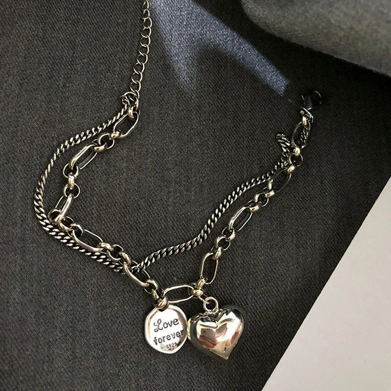 Silberne Halskette mit Herzanhänger und "Love forever"-Gravur, modisches Schmuckstück.