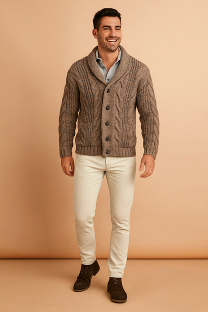 Ganzkörperansicht der braunen Strickjacke zu cremefarbener Hose und dunkelbraunen Stiefeletten vor orangebeigem Studiohintergrund. 4
