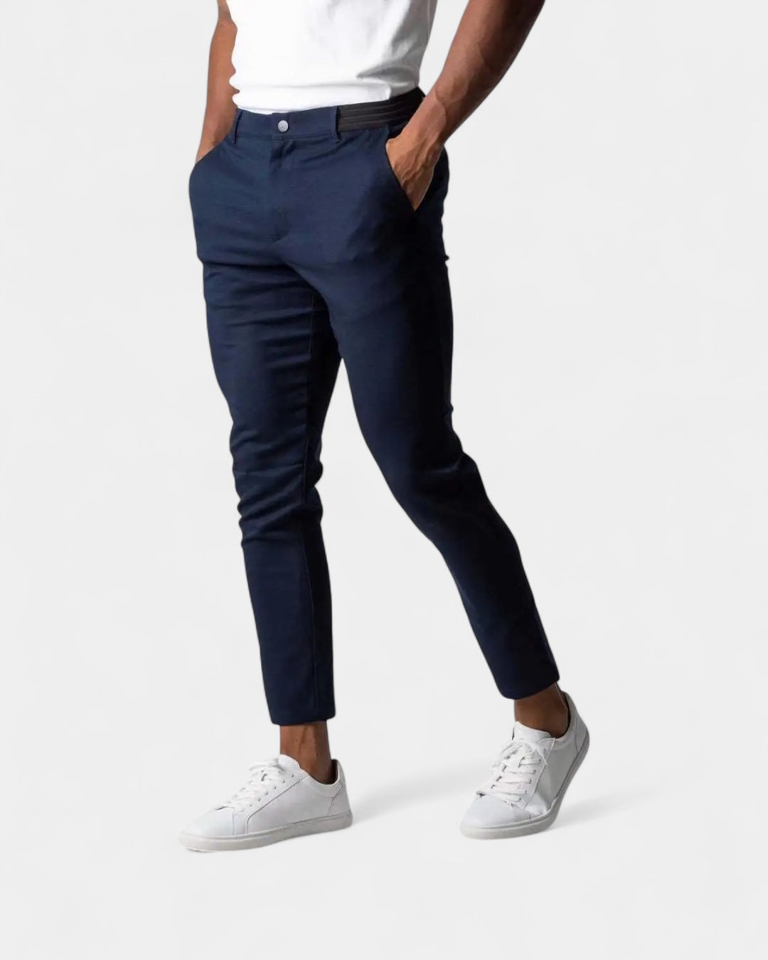 Seitenansicht der Hose in Dunkelblau an einem Model mit weißem Shirt und weißen Sneakern 2