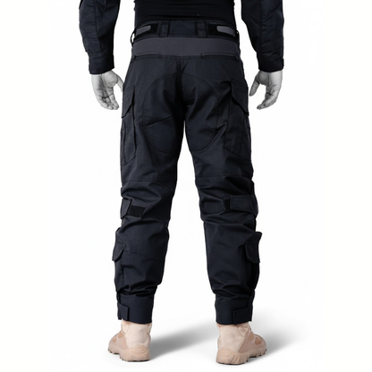 Schwarze Hose an Puppe, direkte Rückansicht mit verstärkter Gesäßpartie, seitlichen Taschen, Klettverschlüssen und Klettbund an den Beinabschlüssen. 10