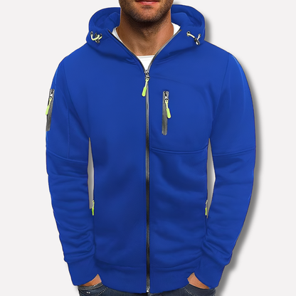 Königsblauer Kapuzenpullover mit neongrünen Reißverschlusszügen an Brusttasche und Ärmel, vor hellem Studiohintergrund an einem Mann gezeigt. 2