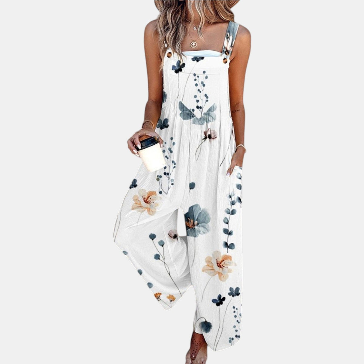 Weiße Latzhose mit zartem Blumen- und Zweigmuster in Blau und Orange, getragen von einem Model 4