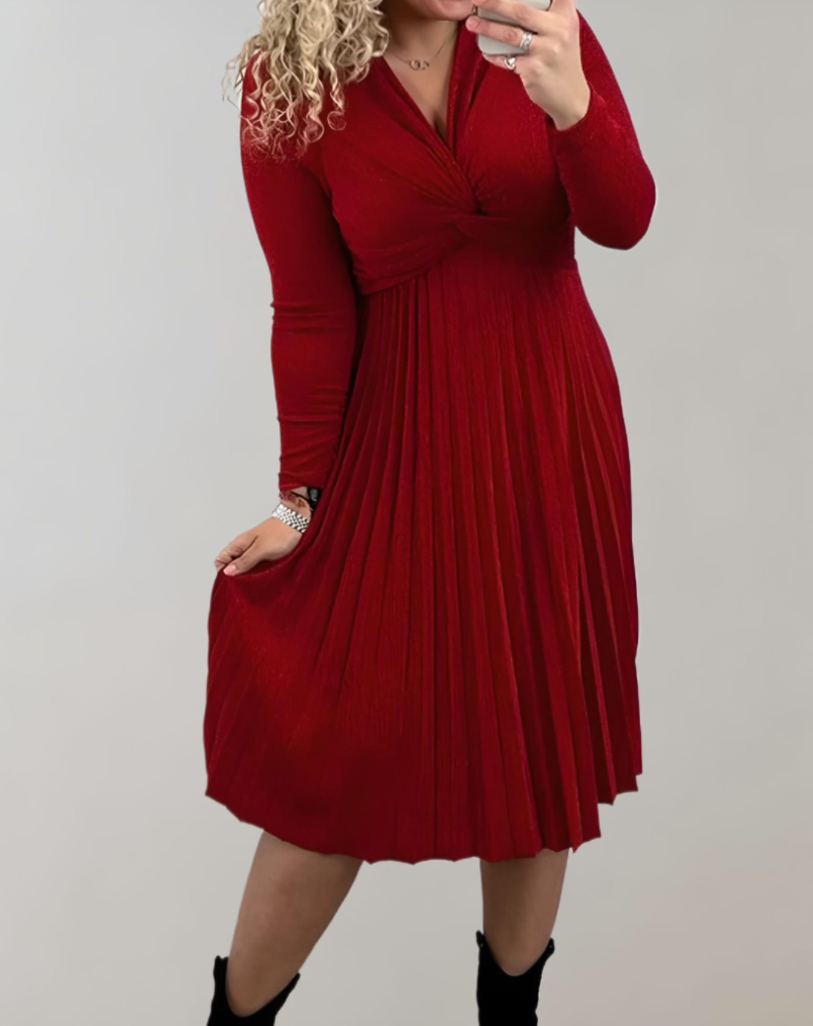 Frau in rotem, plissiertem Kleid, langärmelig, knielang, modisch, elegant, Herbstmode.