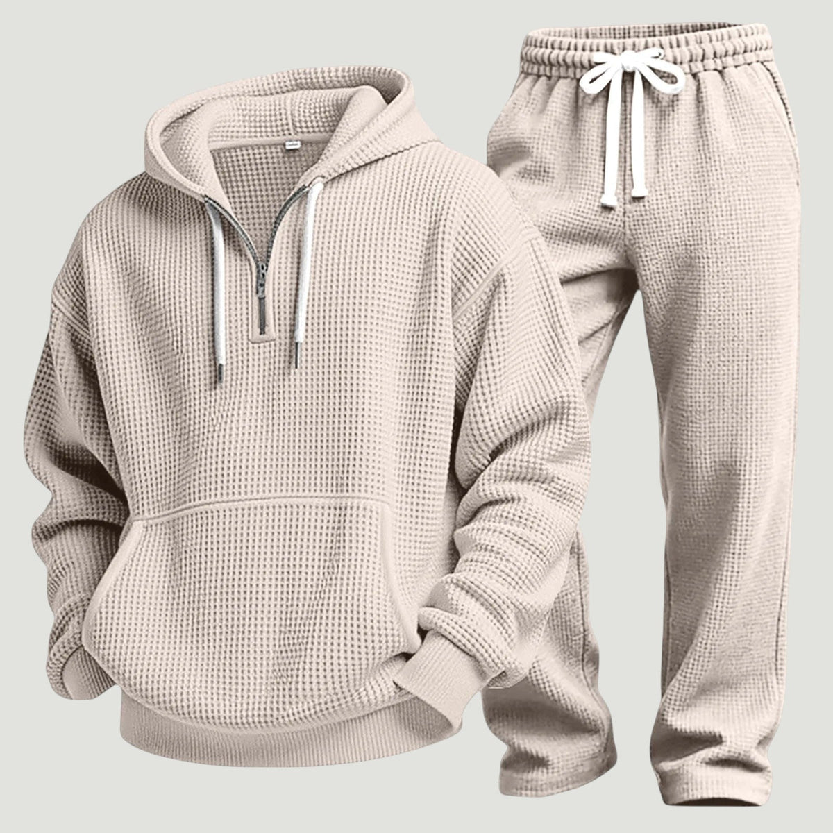 Beiges Waffelstrick-Set aus Hoodie mit halbem Reißverschluss und Jogginghose mit weißem Kordelzug, freigestellt nebeneinander. 8