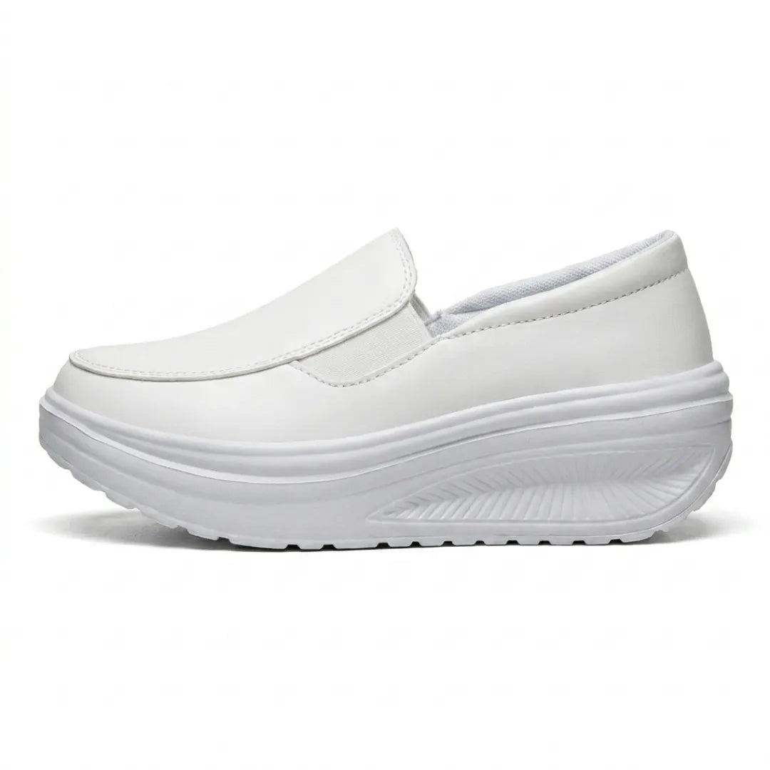 Weißer Slipper mit Keilsohle in der Seitenansicht, Gummizug und profilierte Sohle erkennbar 10